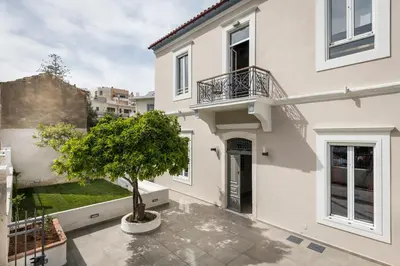 a white house with a tree in a courtyard at Camara Residence in Chania Town