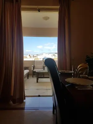 a room with a table and a view of a balcony at Rastoni Apartments in Kissamos