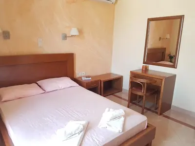 a bedroom with a bed and a desk and a mirror at Rastoni Apartments in Kissamos