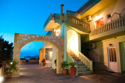 a building with an arch and stairs in front of it at Petritos Rooms and Studios in Falasarna