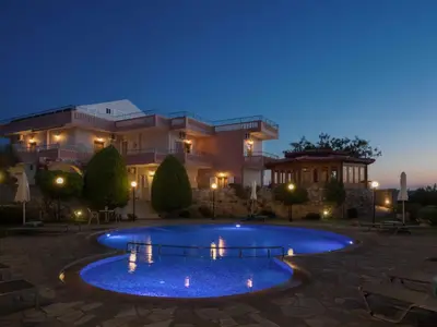 a large house with a large pool at night at Petritos Rooms and Studios in Falasarna