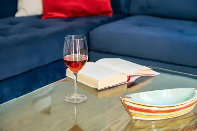 a glass of wine sitting on a table with a book at Boutique Hotel Fortino in Chania Town