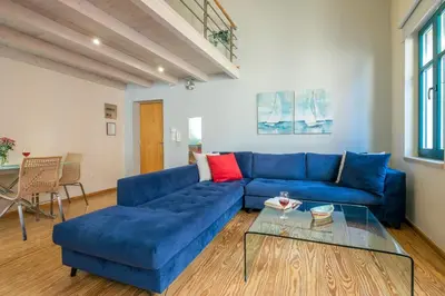 a living room with a blue couch and a glass table at Boutique Hotel Fortino in Chania Town