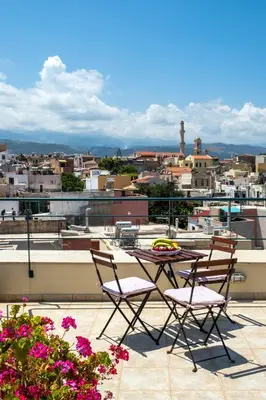 a table and chairs on a balcony with a view of a city at Boutique Hotel Fortino in Chania Town