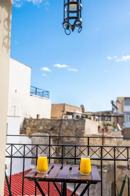a picnic table with two yellow chairs on a balcony at Boutique Hotel Fortino in Chania Town