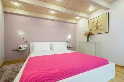 a bedroom with a large bed with a pink blanket at Boutique Hotel Fortino in Chania Town