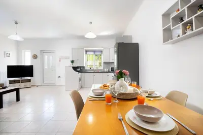 a kitchen and dining room with a table and chairs at Aptera Beach Apartment in Kato Daratso