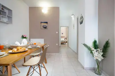 a kitchen and dining room with a table and chairs at Aptera Beach Apartment in Kato Daratso