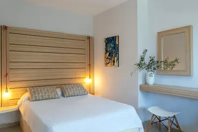 a bedroom with a white bed with a wooden headboard at Coco Studio in Chania Town
