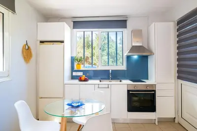 a kitchen with a glass table and white cabinets at Coco Studio in Chania Town