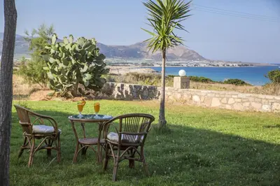 a table with two chairs and two glasses of wine at Kalami Rooms in Falasarna