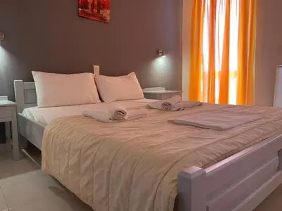 a bedroom with a large bed with towels on it at Kalami Rooms in Falasarna