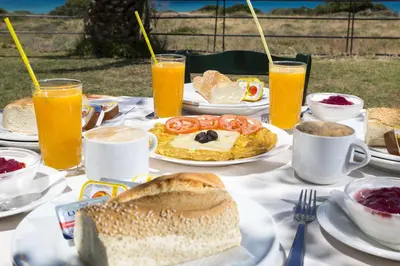 a table topped with plates of food and drinks at Kalami Rooms in Falasarna