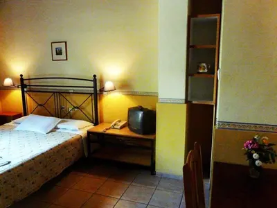 a bedroom with a bed and a desk with a telephone at Alexandros Studios & Apartments in Chania Town