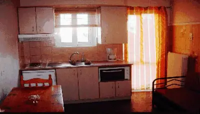 a kitchen with a table and a sink and a window at Alexandros Studios & Apartments in Chania Town