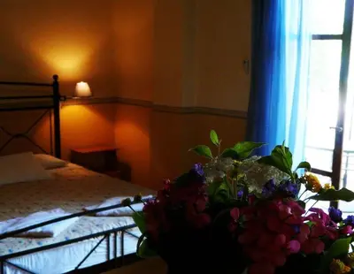 a bedroom with a bed and a bouquet of flowers at Alexandros Studios & Apartments in Chania Town