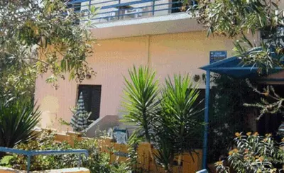 a building with plants and a blue umbrella at Alexandros Studios & Apartments in Chania Town