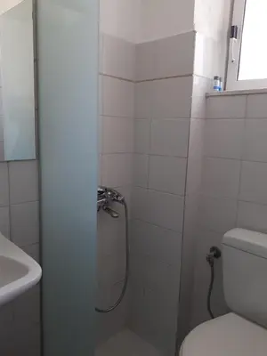 a bathroom with a shower with a toilet and a sink at Diana Rooms in Chania Town