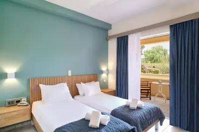 a hotel room with two beds and a window at Pegasus Hotel in Stalos