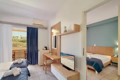 a bedroom with a bed and a tv in a room at Pegasus Hotel in Stalos