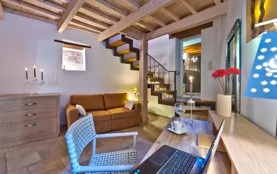 a living room with a couch and a table with a laptop at Kores Boutique Houses in Chania Town