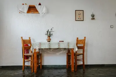 a table with two chairs and a vase on it at Konaki Apartments in Maleme