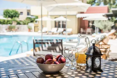 a bowl of fruit sitting on a table next to a bowl of juice at Daphnis Villas in Maleme