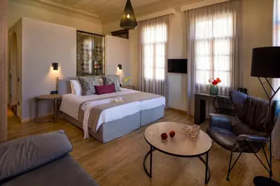 a bedroom with a bed and a living room at ELG Contessa Boutique Hotel in Chania Town