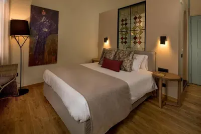 a bedroom with a bed and a painting on the wall at ELG Contessa Boutique Hotel in Chania Town