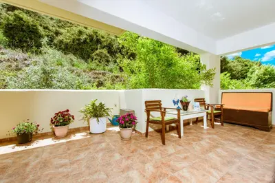 a patio with a table and chairs and plants at Asterina Seaside Apartments in Kalyves