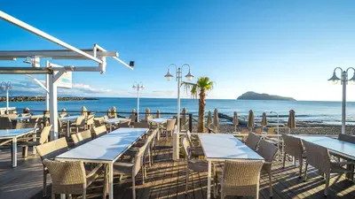a restaurant on the beach with tables and chairs at Marika Beach Hotel in Plataniás