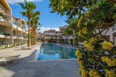 a view of the pool at a resort with palm trees at Marika Beach Hotel in Plataniás