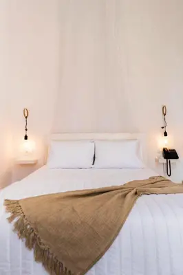 a white bed with a blanket on top of it at Kumba in Chania Town