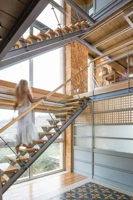 a staircase in a house with a woman walking up it at Olea Villas - Infinity Pool, Hot Tub, Sea Views in Marathi