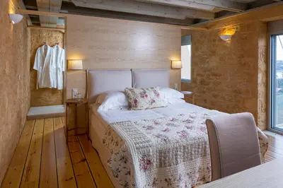 a bedroom with a bed in a wooden room at Olea Villas - Infinity Pool, Hot Tub, Sea Views in Marathi