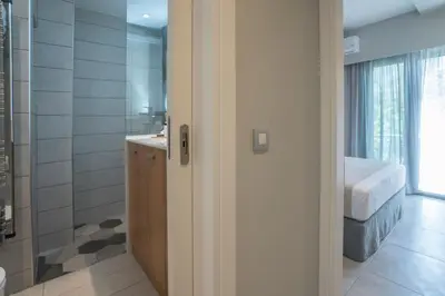 a bathroom with a shower and a bed in a room at Mediterranean Luxury Apartment in Chania Town