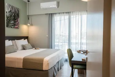a bedroom with a bed and a desk and a window at Mediterranean Luxury Apartment in Chania Town