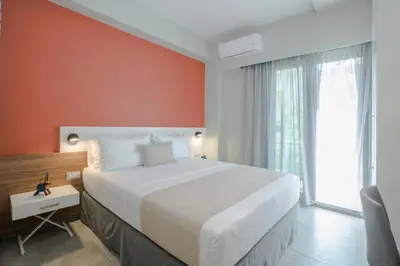 a bedroom with a large bed with an orange wall at Mediterranean Luxury Apartment in Chania Town