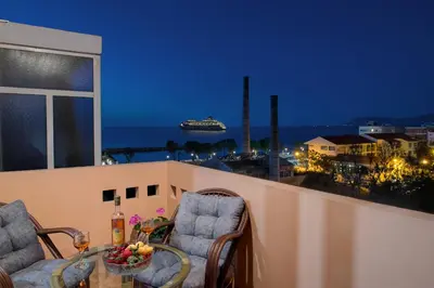 a balcony with a table and chairs and a cruise ship at Fougaro Apartments in Chania Town