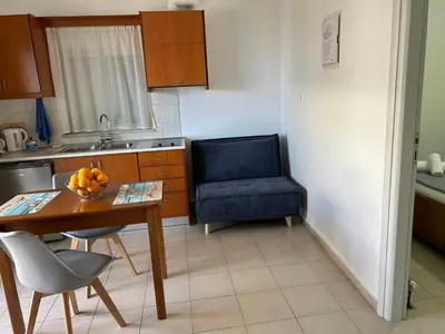 a kitchen with a table and a blue chair at Fougaro Apartments in Chania Town
