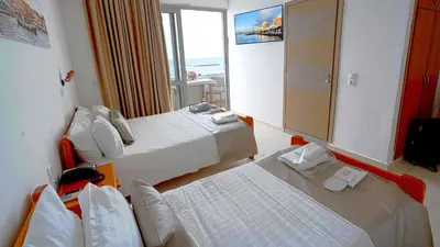 a hotel room with two beds and a mirror at Klinakis Beach Hotel in Chania Town
