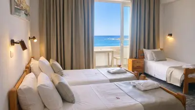 a hotel room with two beds with a view of the ocean at Klinakis Beach Hotel in Chania Town