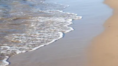 a close up of the sand and water on the beach at Klinakis Beach Hotel in Chania Town