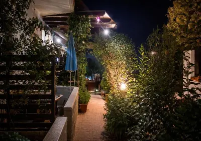 a patio with an umbrella and plants at night at Marianna Apartments in Almirida