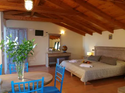 a bedroom with a bed and a table and chairs at Mylos Hotel Apartments in Plataniás