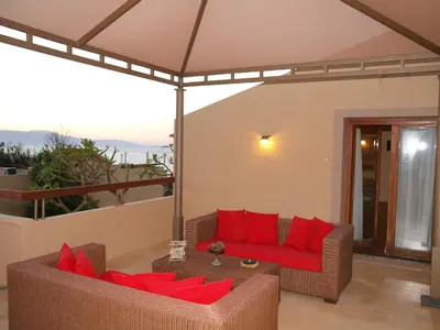 a living room with two couches and red pillows at Mylos Hotel Apartments in Plataniás
