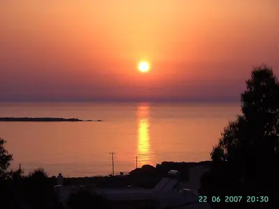 a sunset over the ocean with the sun setting at Golden Sun Apartments in Falasarna