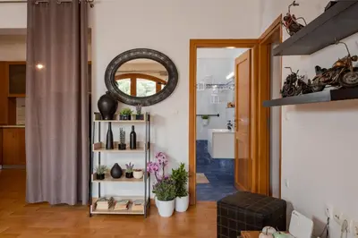a living room with a mirror and a shelf with plants at Zen Serenity Retreat with Great Outdoors, Pool & Parking in Áptera