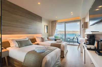 a hotel room with two beds and a balcony at Oniros Residences in Souda