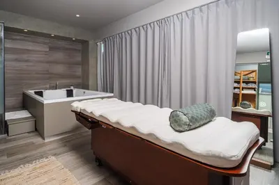 a bathroom with a bath tub and a bed and a bath tub at Oniros Residences in Souda